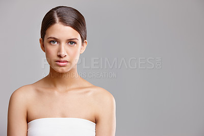 Buy stock photo Studio portrait of a beautiful young woman standing against a gray background