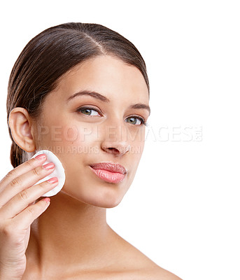 Buy stock photo Studio portrait of a beautiful young woman cleansing her face with a cotton pad
