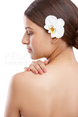 Buy stock photo Studio shot of a beautiful young woman with an orchid in her hair looking over her shoulder