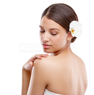 Buy stock photo Studio shot of a beautiful young woman with an orchid in her hair looking over her shoulder