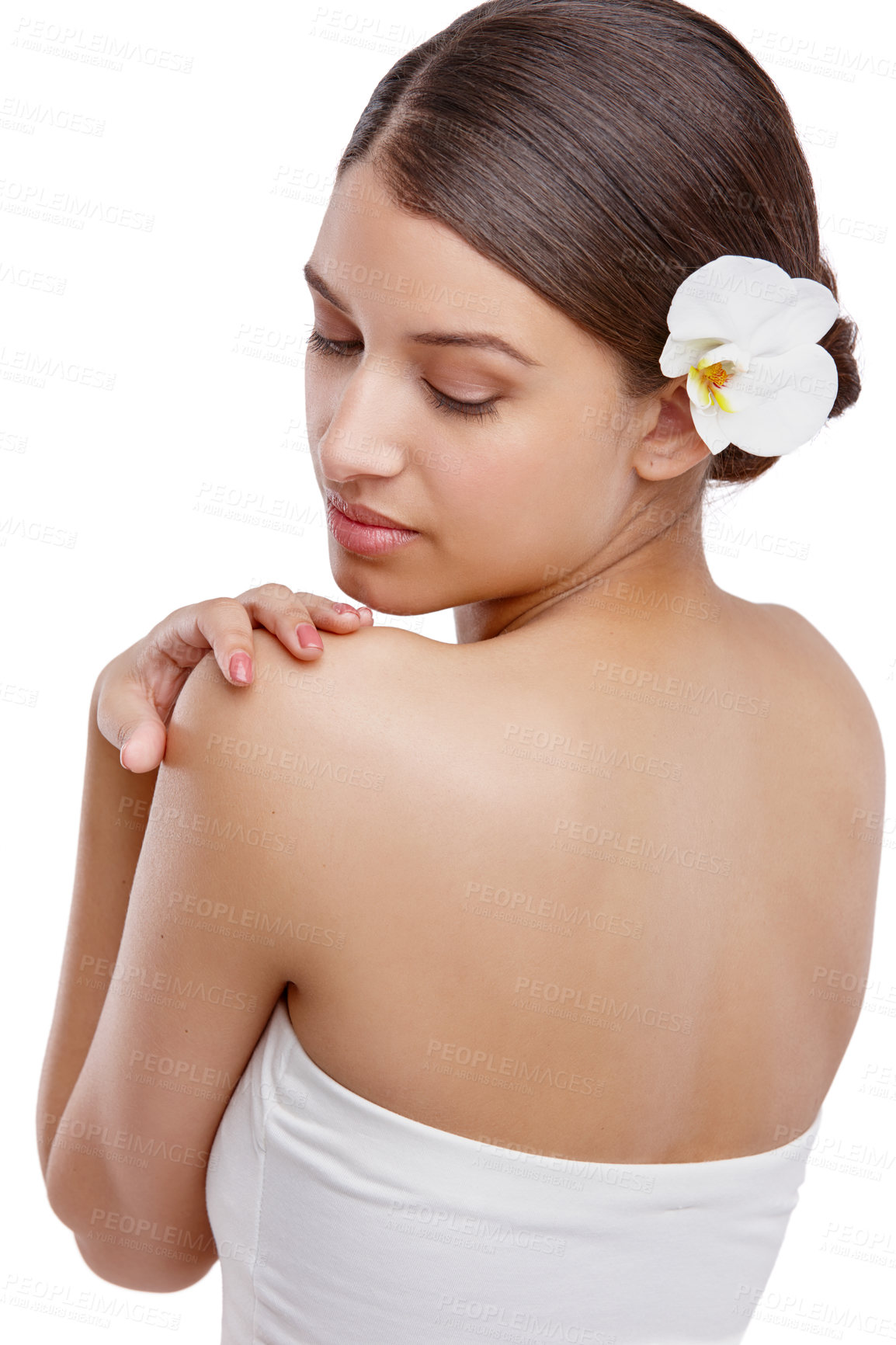 Buy stock photo Studio shot of a beautiful young woman with an orchid in her hair looking over her shoulder