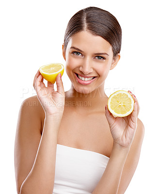 Buy stock photo Studio portrait of a young woman holding up two halves of a lemon
