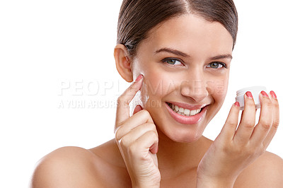 Buy stock photo Studio shot of a beautiful young woman applying moisturizer to her skin