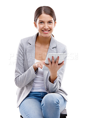 Buy stock photo Studio shot of a beautiful young woman sitting on a stool and using a digital tablet against a white background