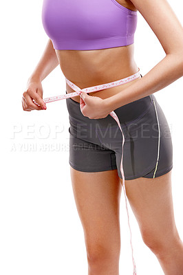 Buy stock photo Cropped shot of a woman measuring her waistline against a white background