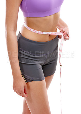 Buy stock photo Cropped shot of a woman measuring her waistline against a white background
