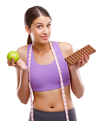 Buy stock photo Shot of a fit young woman holding an apple in one hand and chocolate in the other