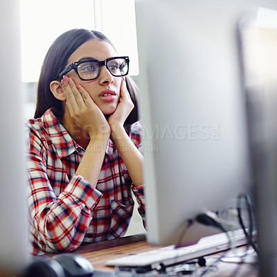Buy stock photo A young designer looking bored while sitting in front of her computer