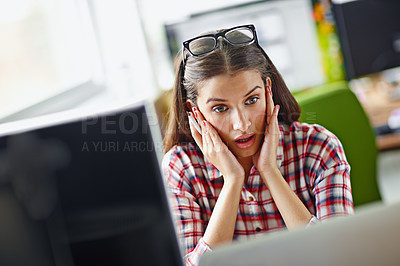 Buy stock photo Shot of a young woman looking surprisingly at her computer screen