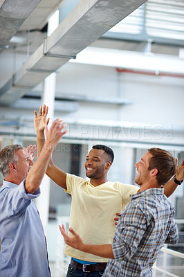 Buy stock photo Shot of three coworkers giving each other a high five at the office