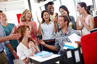Buy stock photo Shot of a diverse group of coworkers celebrating good news at the office