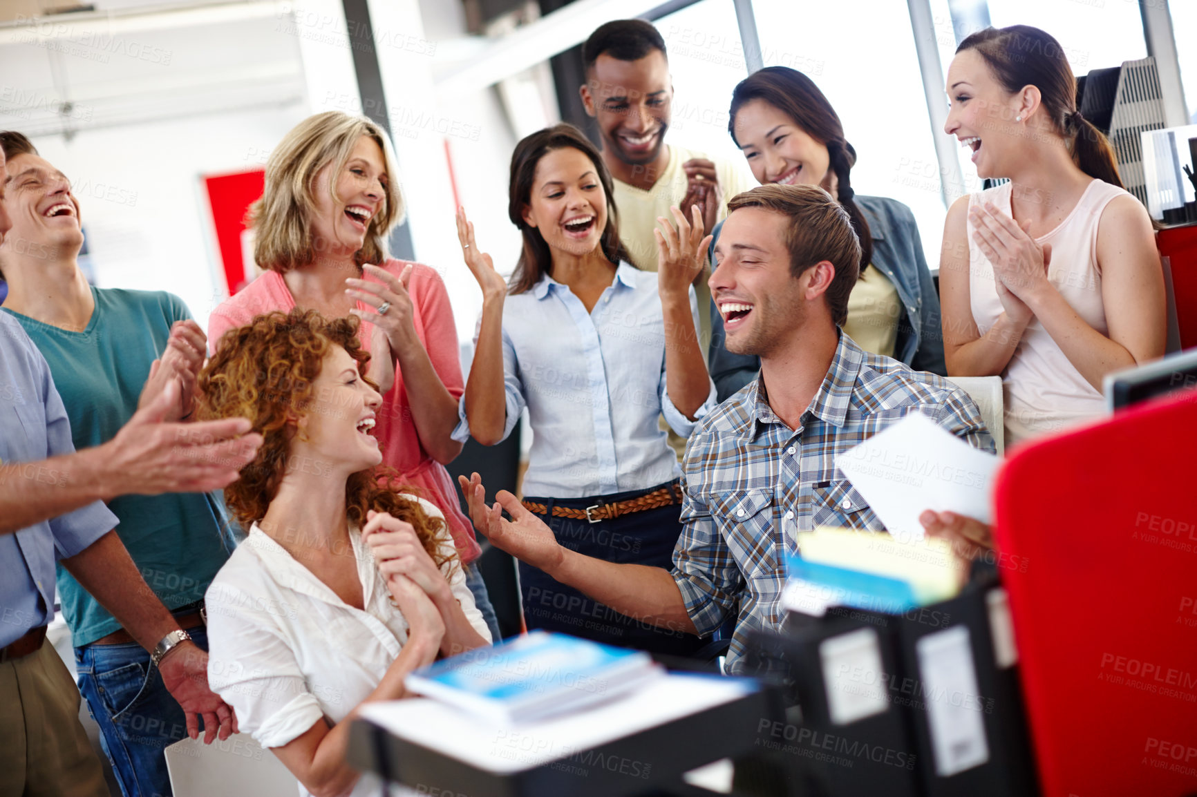 Buy stock photo Shot of a diverse group of coworkers celebrating good news at the office