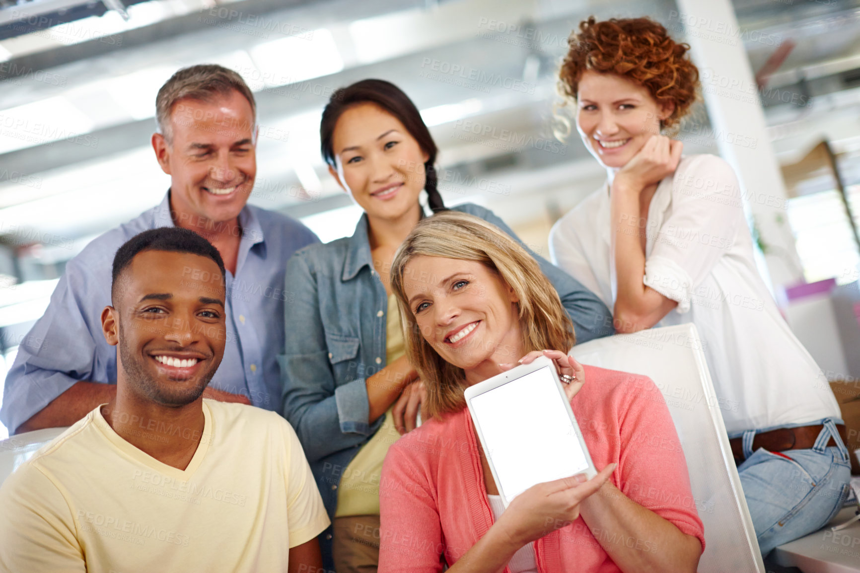 Buy stock photo Portrait of a diverse group of coworkers showing you a digital tablet in a casual office environment 