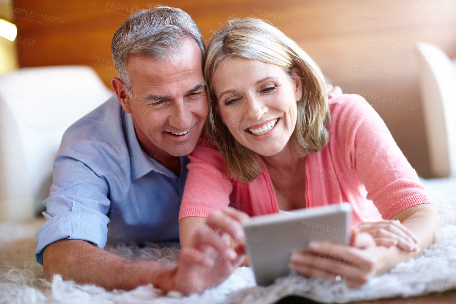 Buy stock photo Shot of a loving husband and wife using a digital tablet together at home
