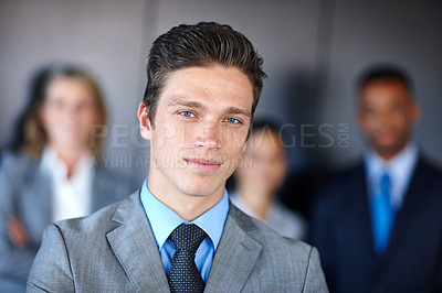 Buy stock photo Shot of a confident businessman standing in front of his team at the office