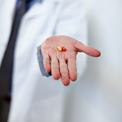 Buy stock photo Cropped shot of a doctor holding two capsules in his hand