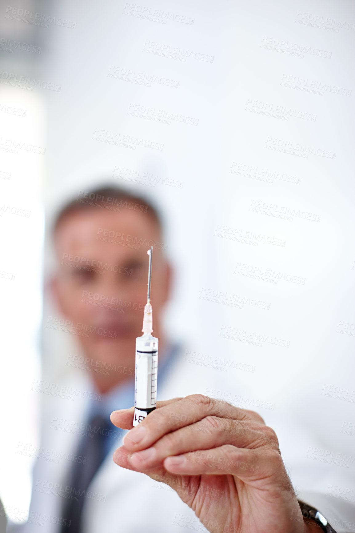 Buy stock photo Closeup shot of a doctor holding a syringe in his hand