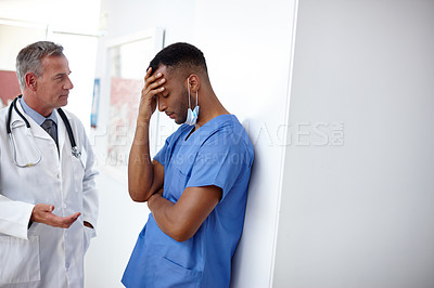 Buy stock photo Shot of a doctor and a surgeon having a difficult conversation 