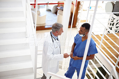 Buy stock photo Shot of a doctor and a surgeon having a serious discussion 