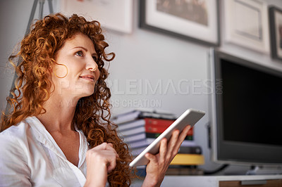 Buy stock photo Shot of an attractive woman using her tablet in an informal work environment