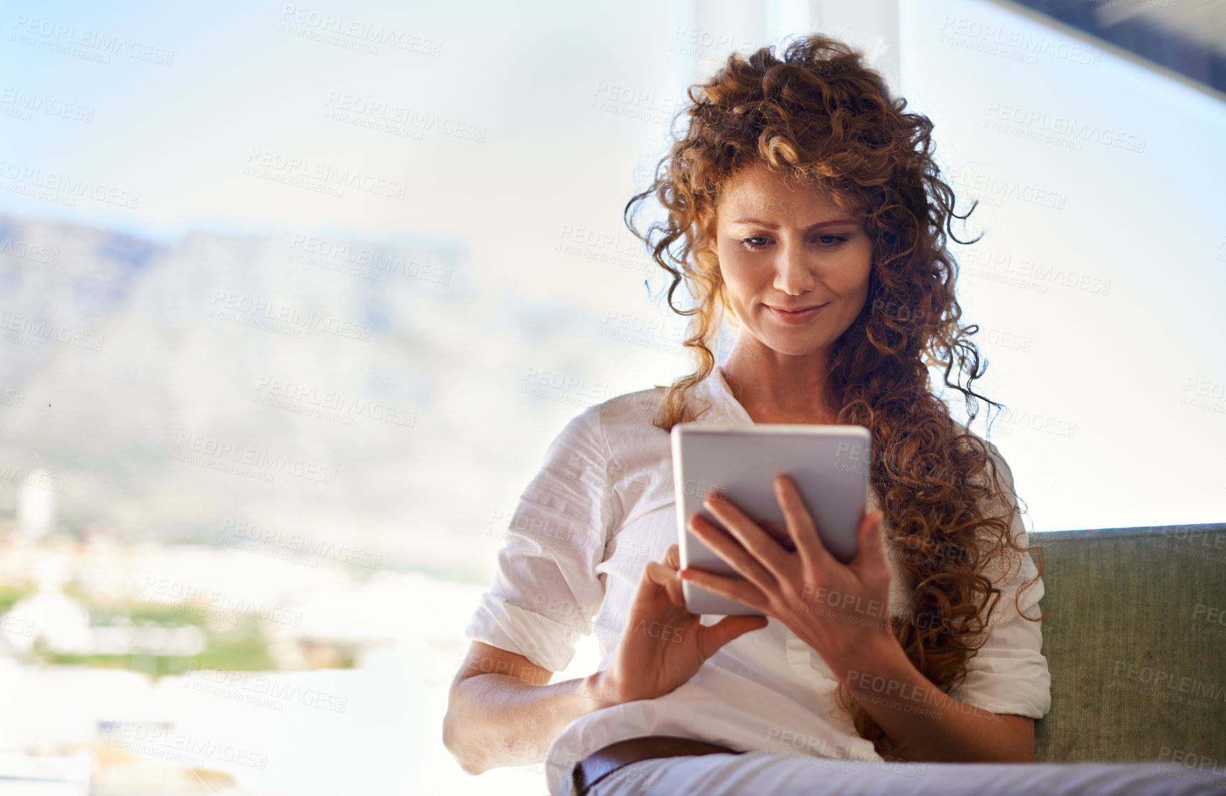 Buy stock photo Shot of an attractive woman using her tablet in an informal work environment