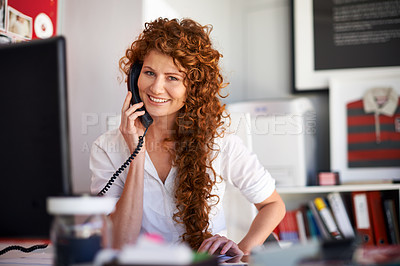 Buy stock photo Shot of an attractive female designer talking on the phone at her desk