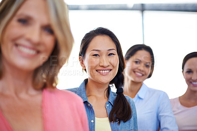 Buy stock photo Portrait of a young woman standing with her business colleagues at the office
