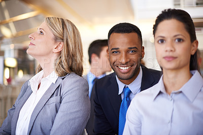 Buy stock photo Portrait of a handsome young businessman sitting amongst his colleagues