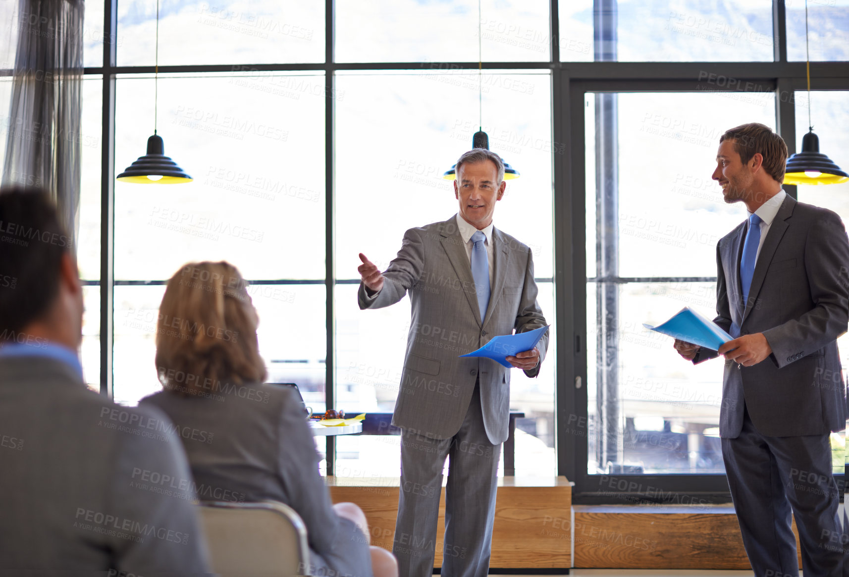 Buy stock photo Shot of two businessmen delivering a work presentation to their colleagues