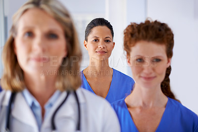 Buy stock photo Portrait of an attractive female nurse standing with her colleagues