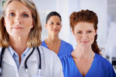 Buy stock photo Portrait of an attractive female nurse standing with her colleagues