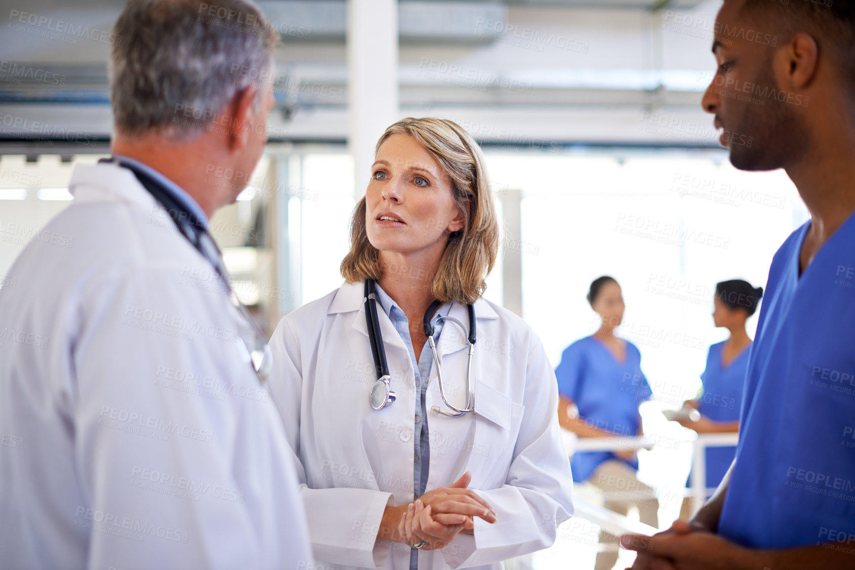 Buy stock photo Shot of a group of medical professionals discussing work at a hospital
