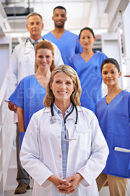 Buy stock photo Portrait of a diverse team of medical professionals standing on a staircase in a hospital