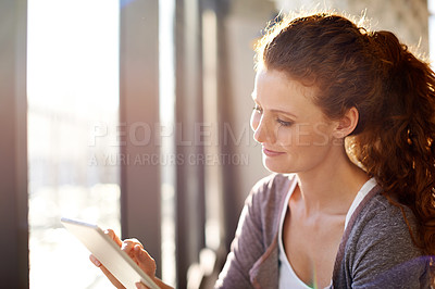 Buy stock photo Shot of a beautiful woman using her digital tablet indoors