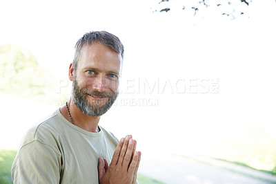 Buy stock photo Portrait of a handsome mature man standing with his hands in prayer position outdoors