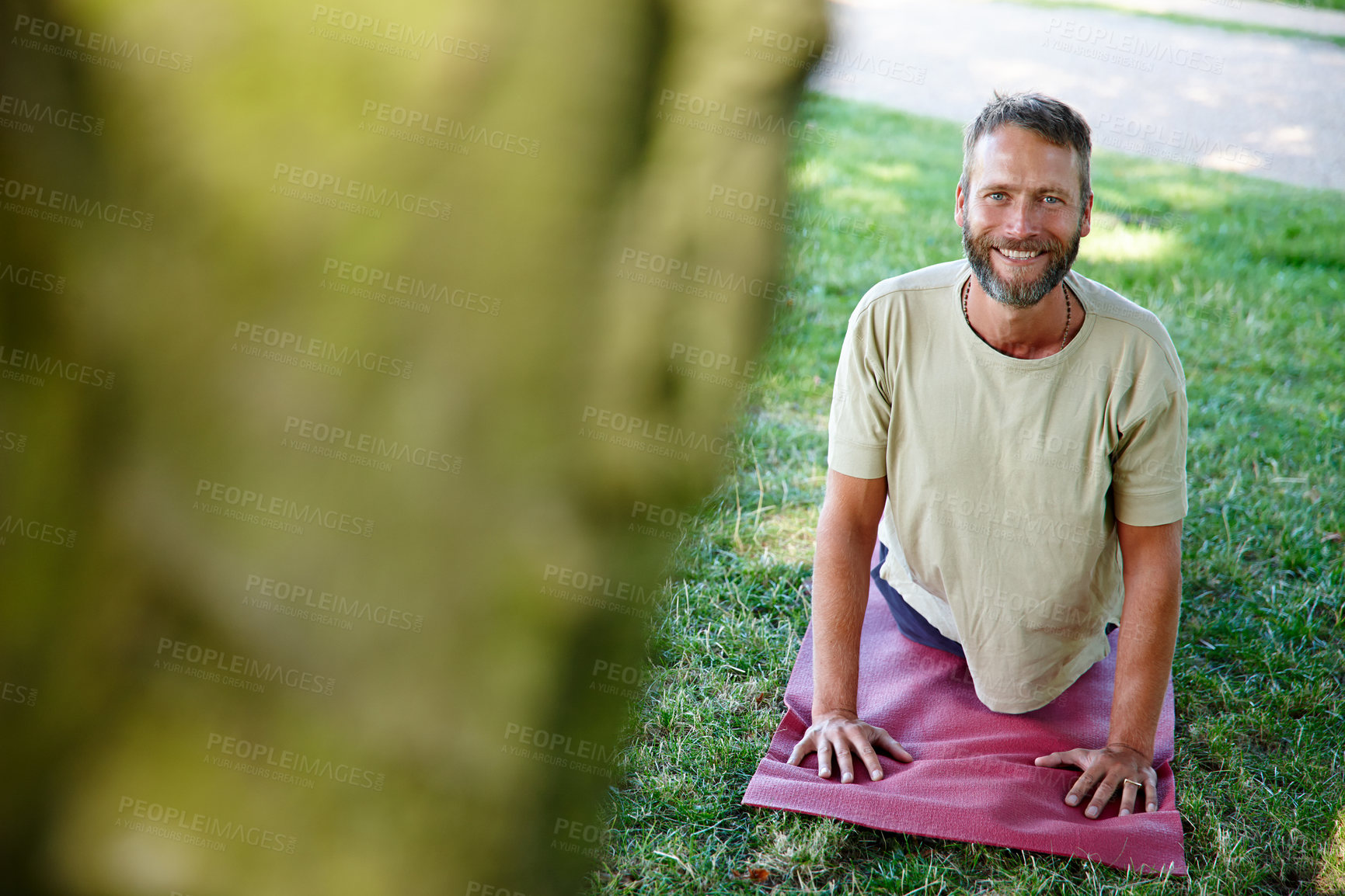 Buy stock photo Outdoor, man and portrait on yoga mat with stretching for fitness, exercise and workout in Germany. Male person, park and smile or happy on grass for self care, health and wellness as routine