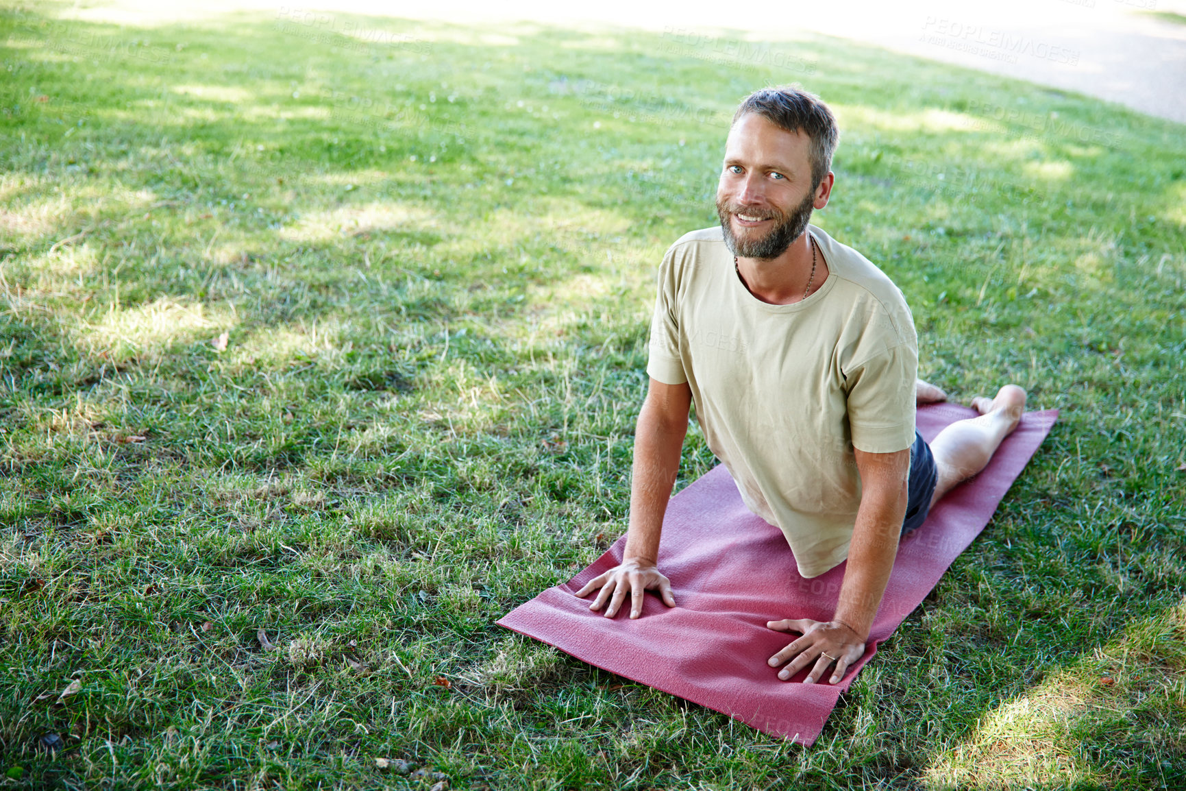 Buy stock photo Park, man and portrait on yoga mat with stretching for fitness, exercise and workout in Germany. Male person, outdoor and smile or happy on grass for self care, health and wellness as routine