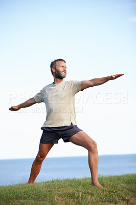 Buy stock photo Happy, man and stretching on grass with yoga for exercise, balance and mobility in nature. Pilates, mature yogi and warrior pose on lawn for workout, holistic wellness and posture with fitness mockup