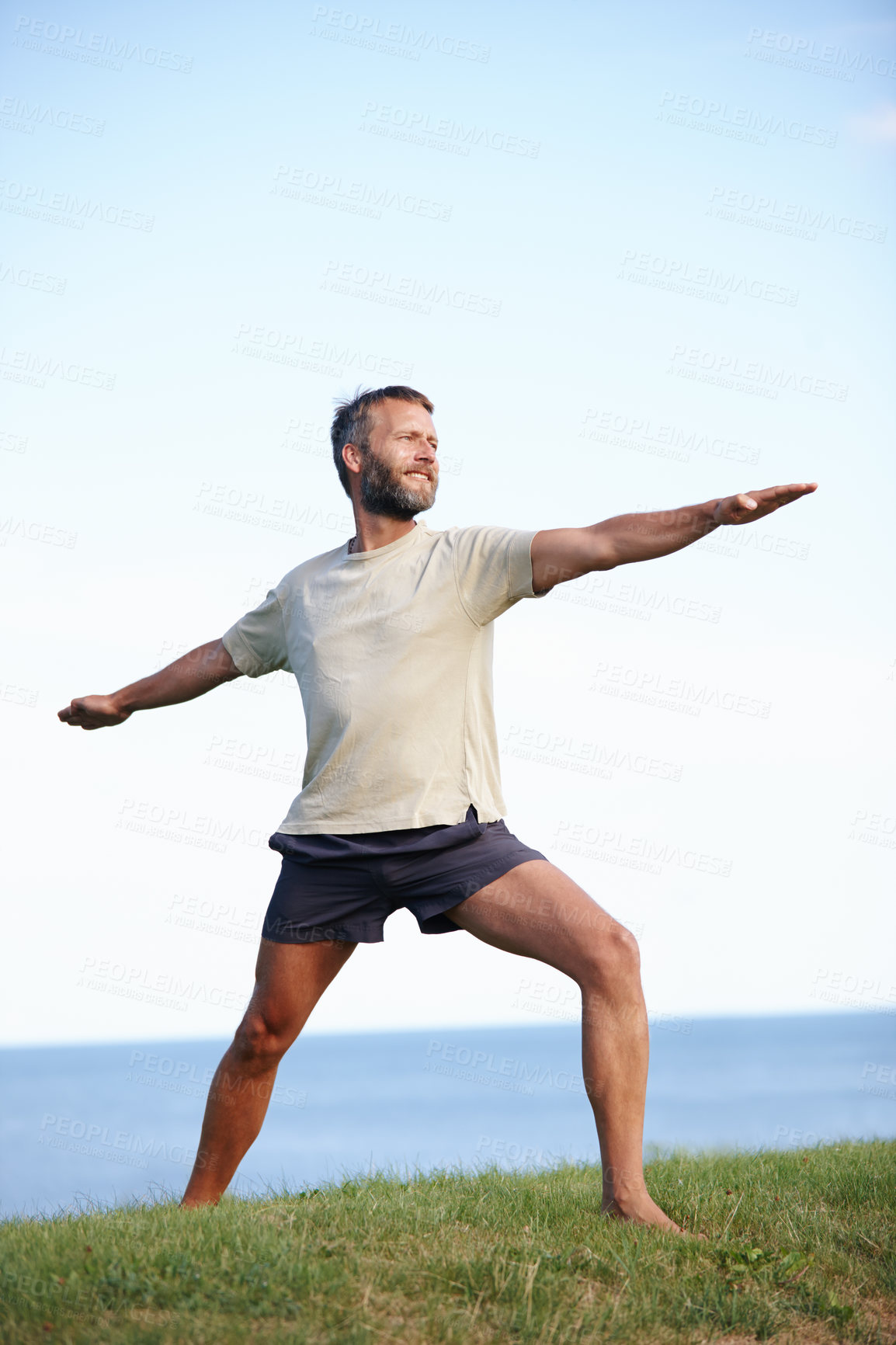 Buy stock photo Happy, man and stretching on grass with yoga for exercise, balance and mobility in nature. Pilates, mature yogi and warrior pose on lawn for workout, holistic wellness and posture with fitness mockup