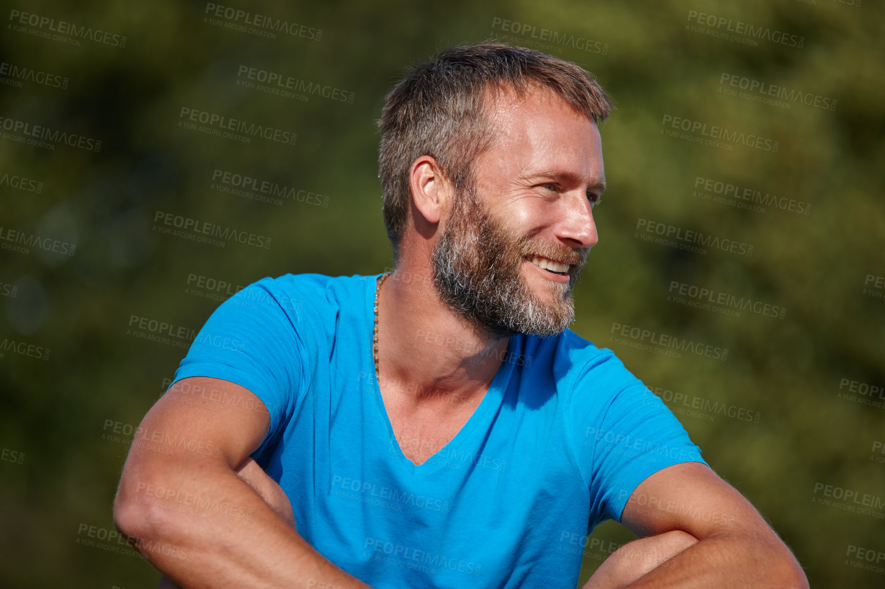 Buy stock photo One fit mature man relaxing after workout and exercise, sitting alone in nature park outside. Smiling happy active, sporty man enjoying free time on weekend after cardio health and routine training