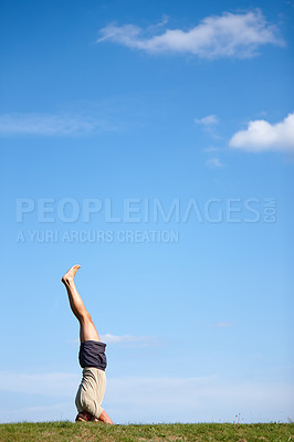 Buy stock photo Man, blue sky and handstand with grass field in nature for holistic workout, mindfulness or exercise. Male person, yogi or active with balance on lawn with mockup space for health and wellness in air