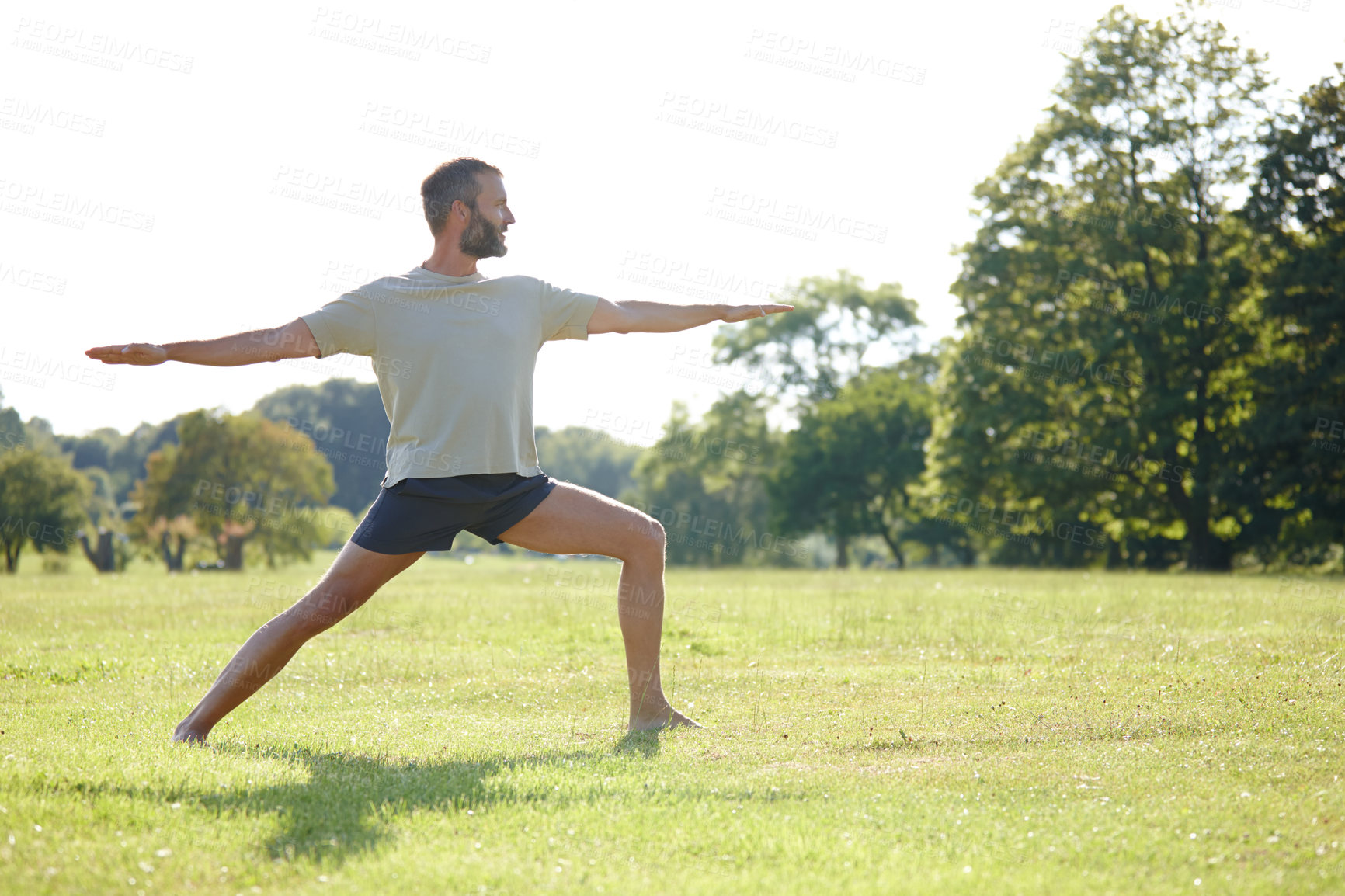 Buy stock photo Nature, man and stretching at park with yoga for exercise, balance and mobility on grass. Pilates, mature yogi and warrior pose on lawn for workout, holistic wellness and posture with fitness outdoor