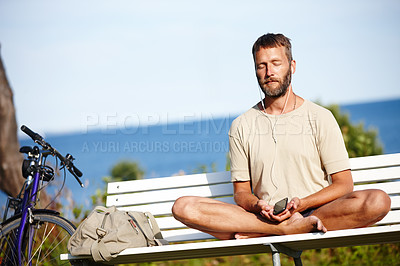 Buy stock photo Shot of a mature man listening to music while doing a relaxation exercise outdoors