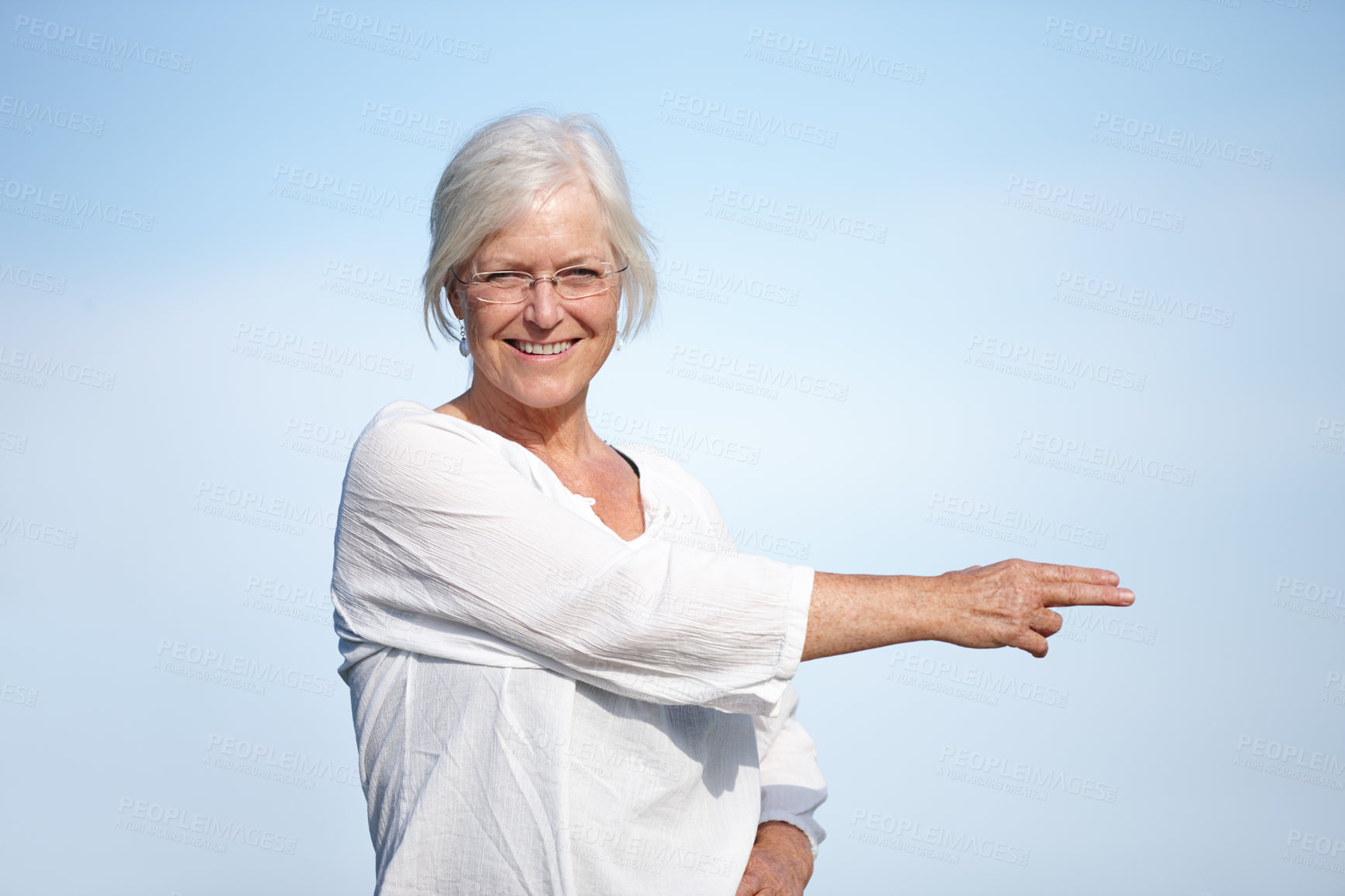 Buy stock photo Sky, mature woman and stretching with pointing on portrait for fitness, yoga and exercise. Female person, outdoor and smile or satisfied for retirement on break with self care, wellness and health