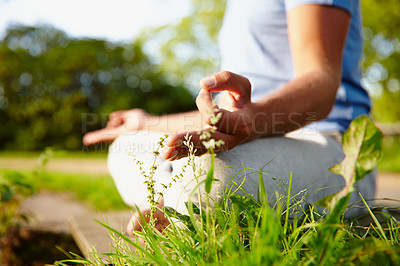 Buy stock photo Closeup of one man meditating in harmony with om finger gesture practising yoga on grass outdoors with copyspace. Calm and relaxed guy feeling zen praying quietly for stress relief and peace of mind 