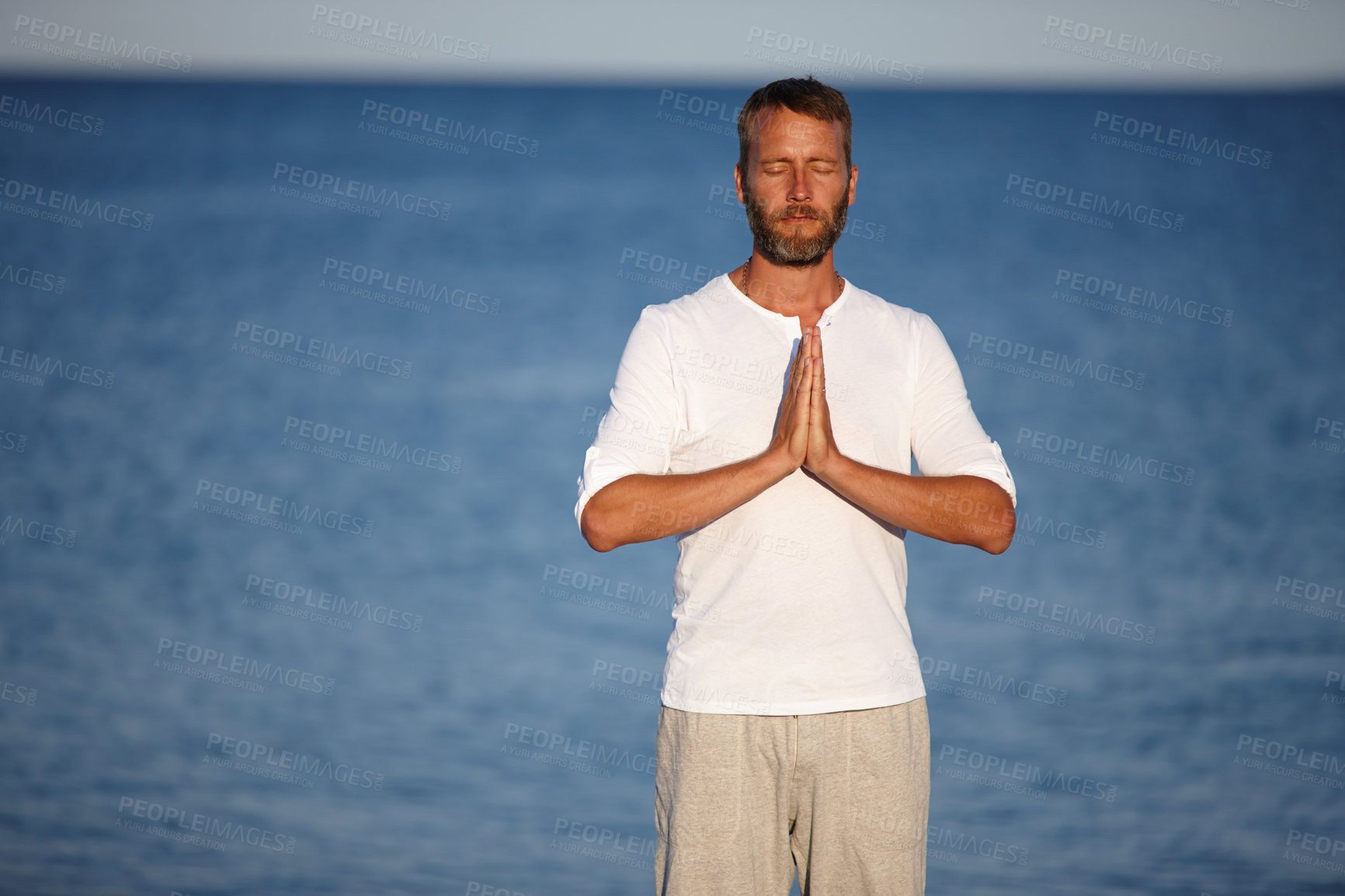 Buy stock photo Mature, man and meditation with yoga at ocean for mindfulness healing, spiritual peace and performance. Male person, zen and water with chakra zen for mental health, mindset balance and nature aura