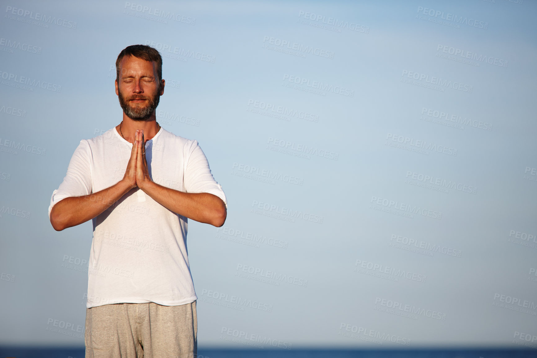 Buy stock photo Man, meditation and blue sky with yoga at ocean for mindfulness healing, spiritual peace and performance. Mature person, zen and namaste with chakra for mental health, mindset balance and nature aura