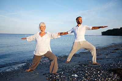 Buy stock photo People, smile and yoga on beach for fitness, wellness and holistic activity for mental health. Mature pilates group, warrior pose or happy on seaside for spiritual healing, balance or peace in nature