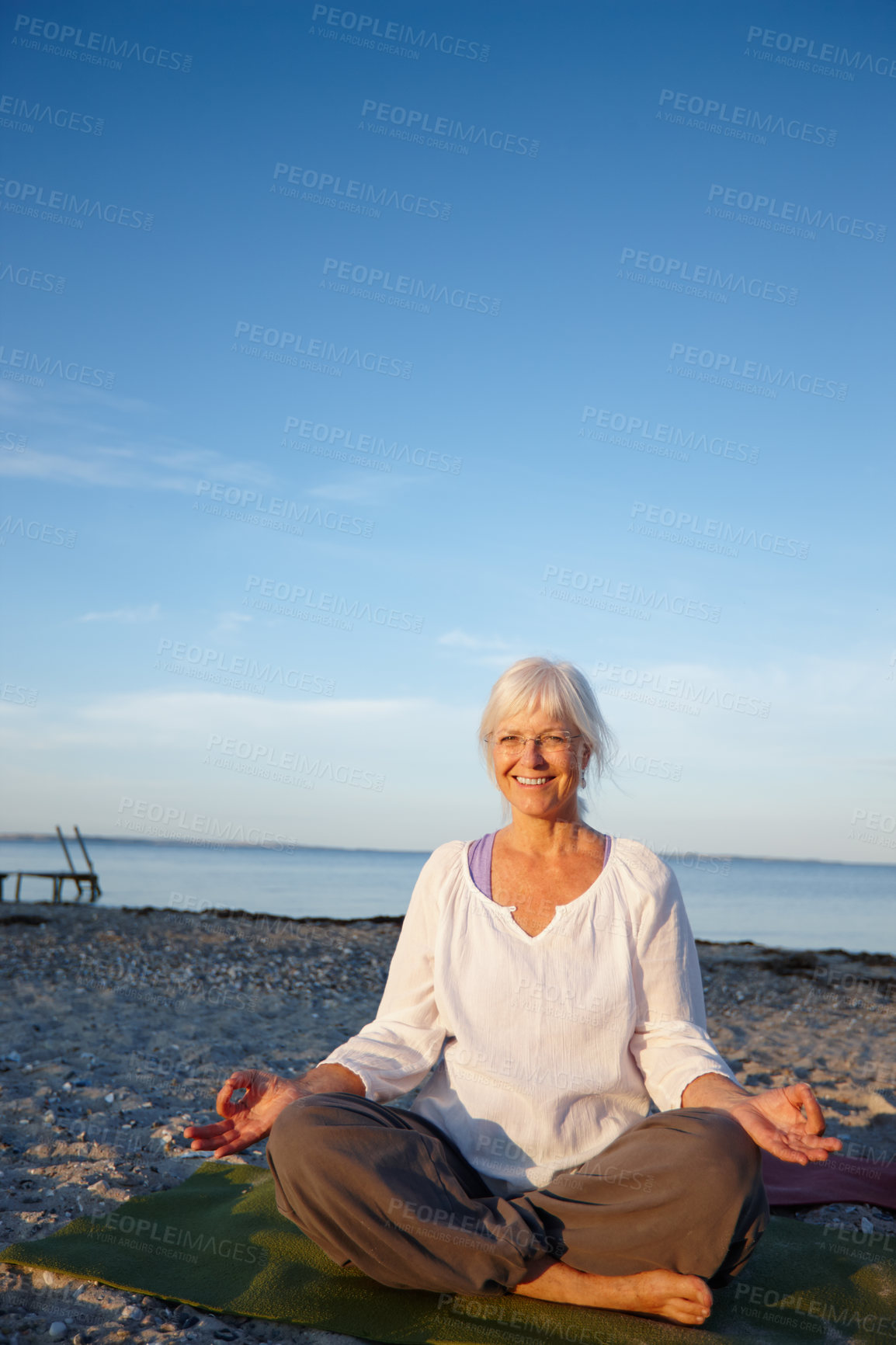 Buy stock photo Portrait, woman and meditation for yoga by ocean with holistic care, spiritual wellness and mindfulness. Mature person, namaste and pilates peace, mindset healing and performance with fitness outdoor