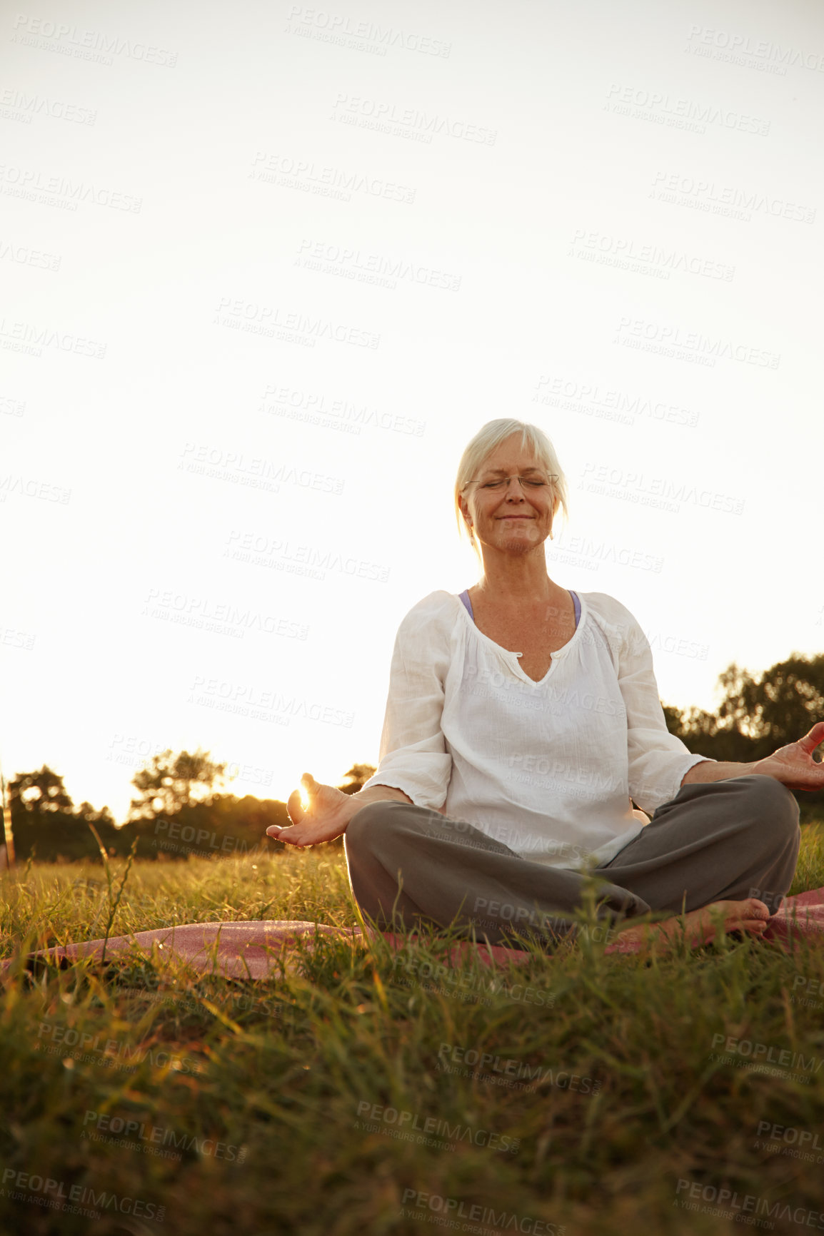 Buy stock photo Woman, relaxing and meditation with yoga outdoor for mindfulness, nature peace and holistic healing on grass. Mature person, smile and pilates with mental health care, gratitude and spiritual fitness